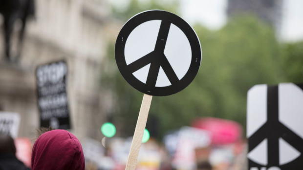 Ein Demonstrant hält ein Peace-Zeichen hoch. Foto: Drop Ink / Shutterstock